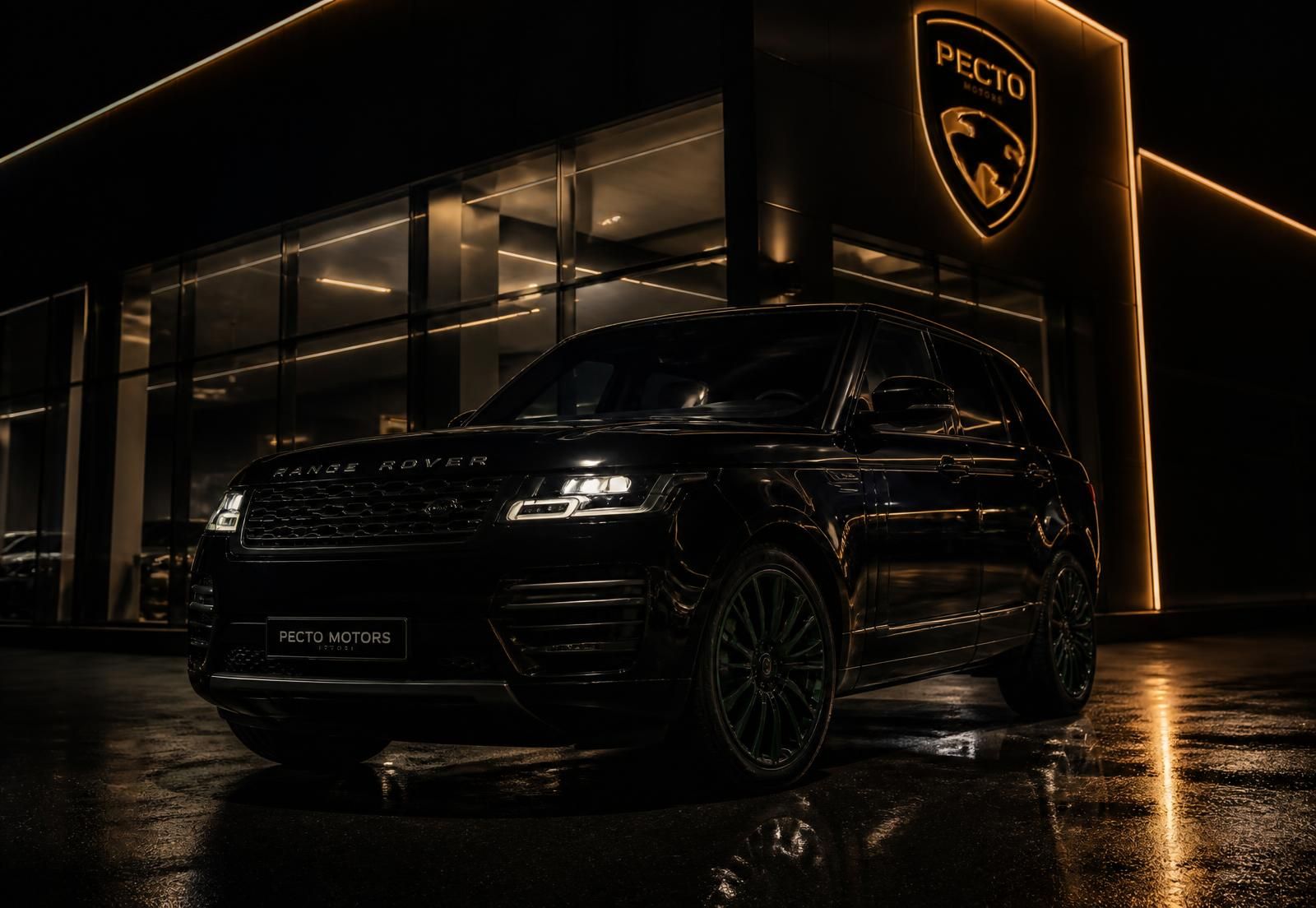 Black luxury SUV at a dealership at night