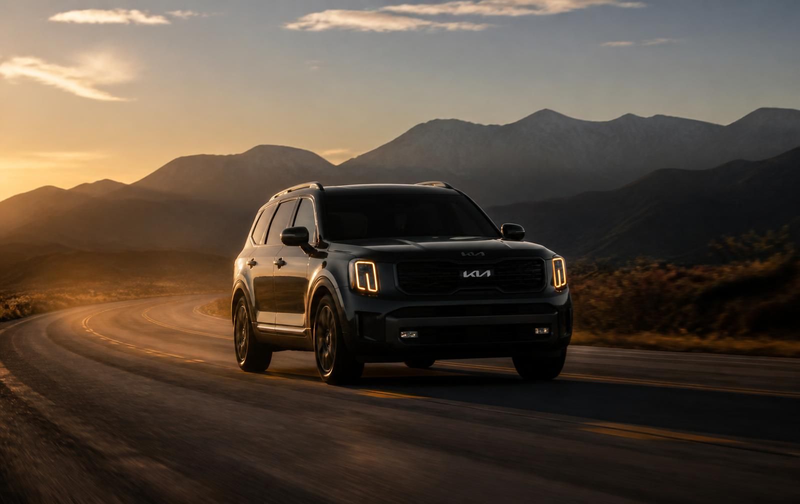 A family SUV on an open highway at golden hour